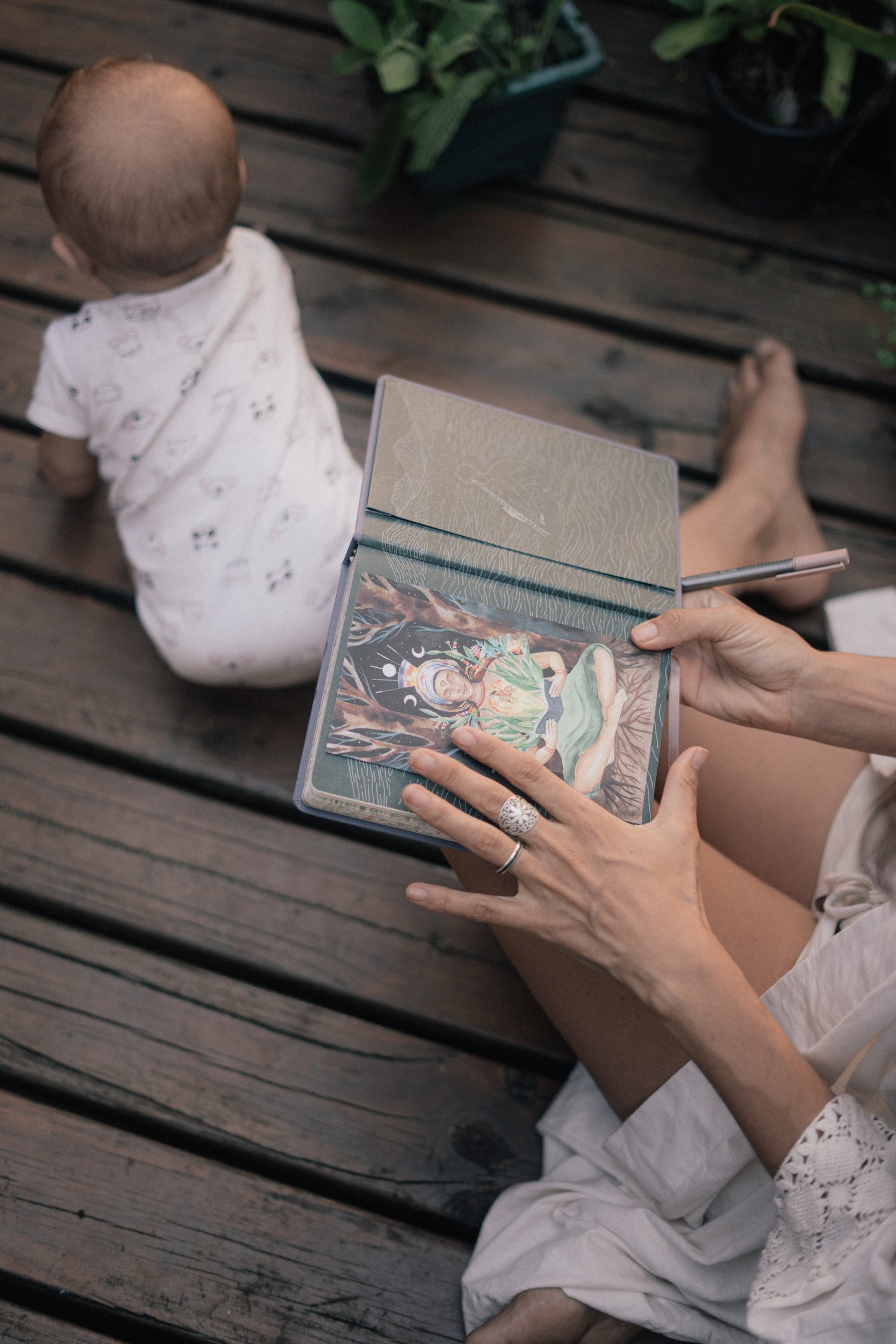 Femme qui regarde le Mandala Lunaire avec bébé à l'extérieur