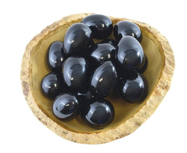 Œufs de yoni en obsidienne dans un bol en bois