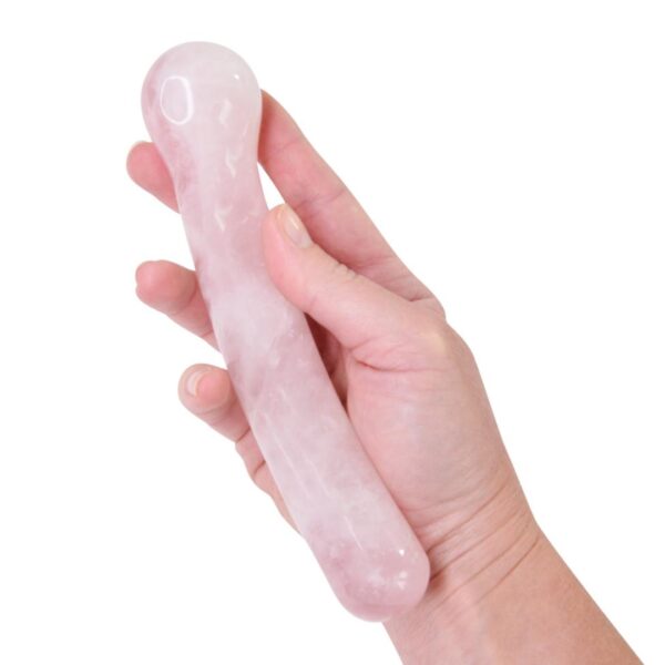 Dildo courbé en quartz rose dans une main